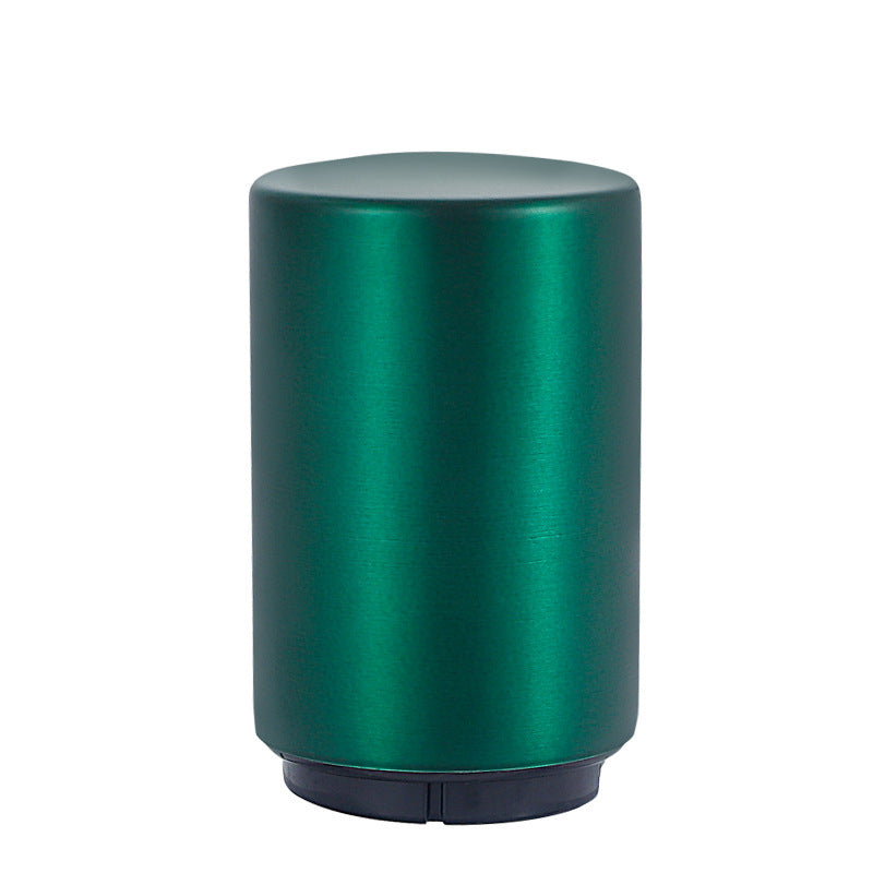 Green cylindrical portable beer bottle opener on a white background