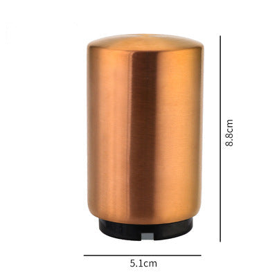 Bronze-colored cylindrical portable beer bottle opener with dimensions on a white background