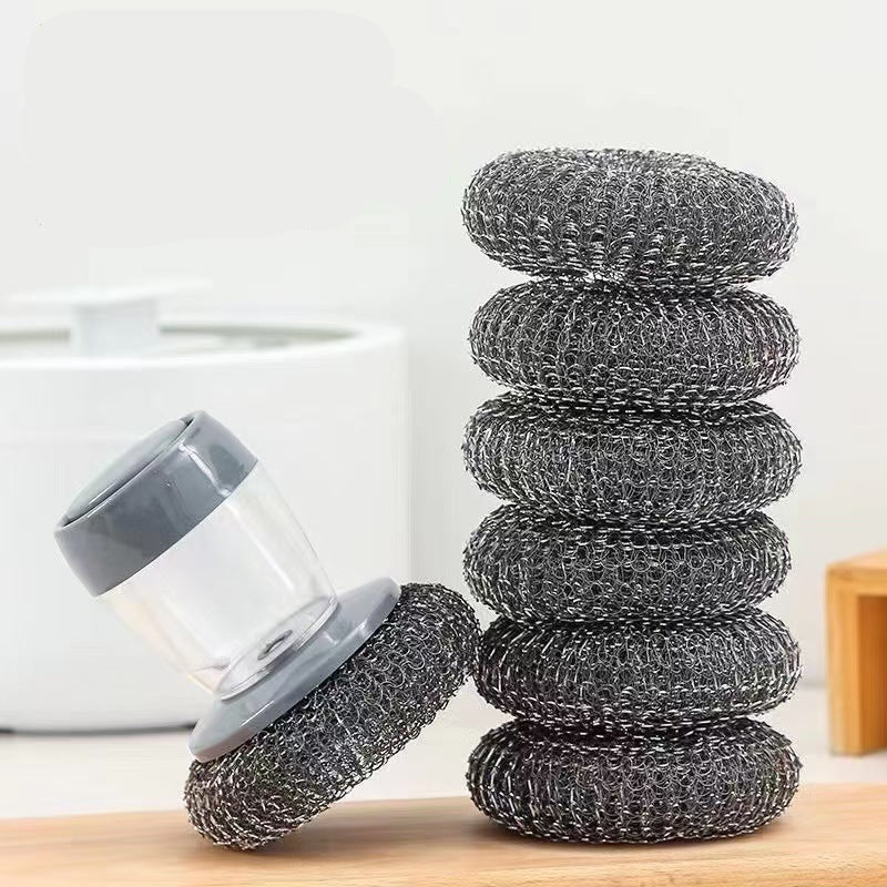 Stack of metal scrubber pads on a wooden surface with text in the background