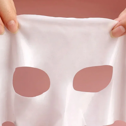 Bio-collagen Face Mask on a white cloth held by hands against a pink background