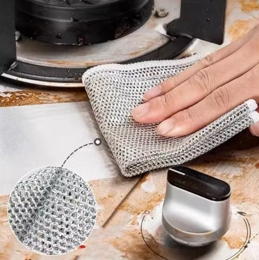 Person using a metallic scrubber on a stovetop with a close-up of the scrubber's texture.