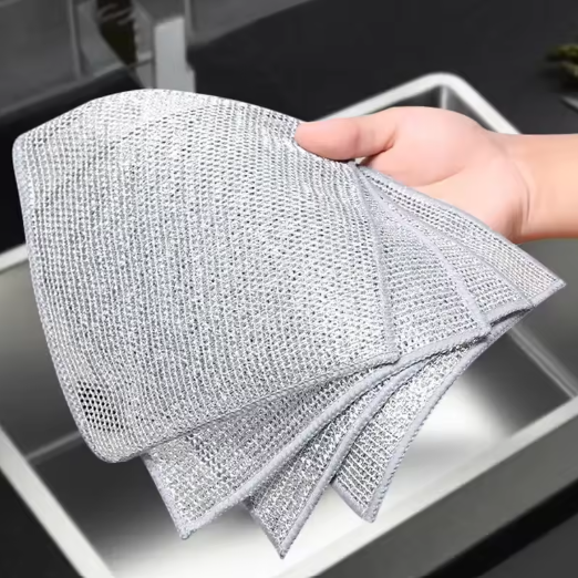 Person holding a textured cleaning cloth over a sink